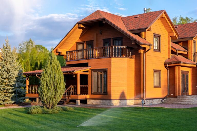 Casa in legno su più piani immersa nel verde con un prato e degli alberi