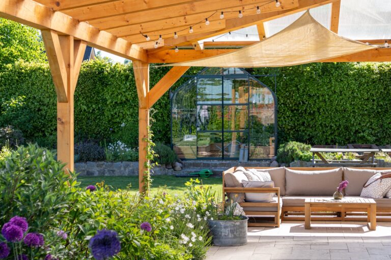 Coperture in legno per terrazzi con divanetto e fiori